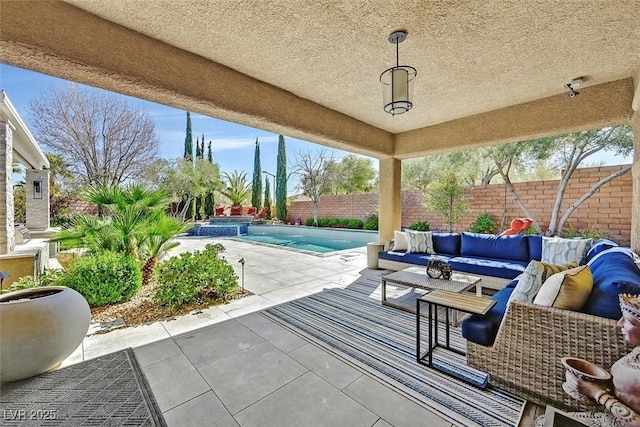 view of patio with a fenced backyard, a pool with connected hot tub, and an outdoor living space