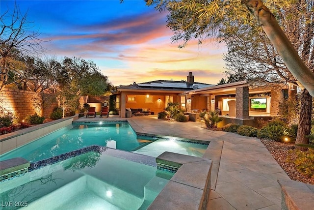 view of pool with a patio area and a pool with connected hot tub