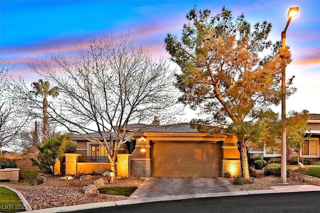 view of front of home with a garage, driveway, and stucco siding