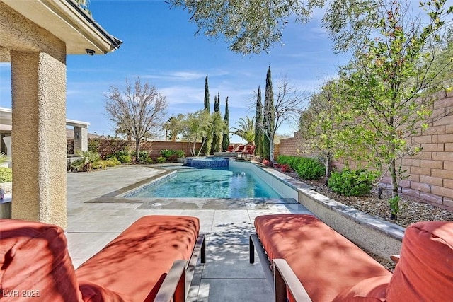 view of swimming pool featuring a fenced backyard, a pool with connected hot tub, and a patio