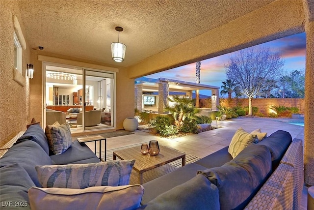 patio terrace at dusk with fence and an outdoor living space