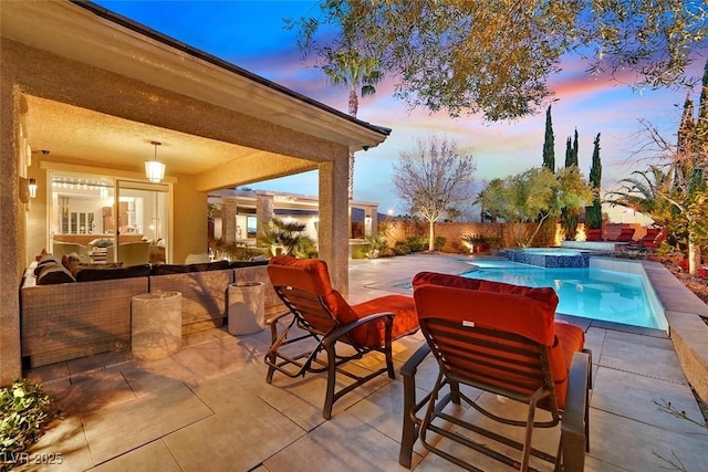 pool at dusk featuring a fenced backyard, a pool with connected hot tub, and a patio