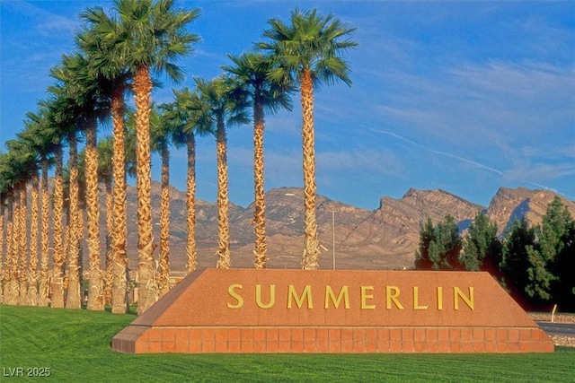 community / neighborhood sign featuring a yard and a mountain view