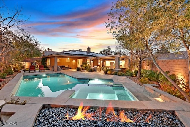 view of pool with a fenced backyard, a patio area, an outdoor living space with a fire pit, and a pool with connected hot tub