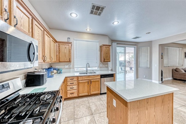 kitchen featuring visible vents, appliances with stainless steel finishes, light countertops, and a sink