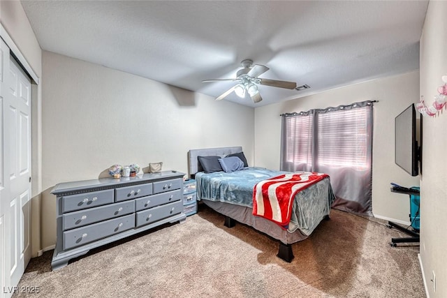 bedroom featuring carpet flooring, visible vents, baseboards, a ceiling fan, and a closet