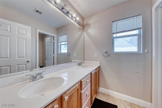 full bath with visible vents, a sink, baseboards, and double vanity