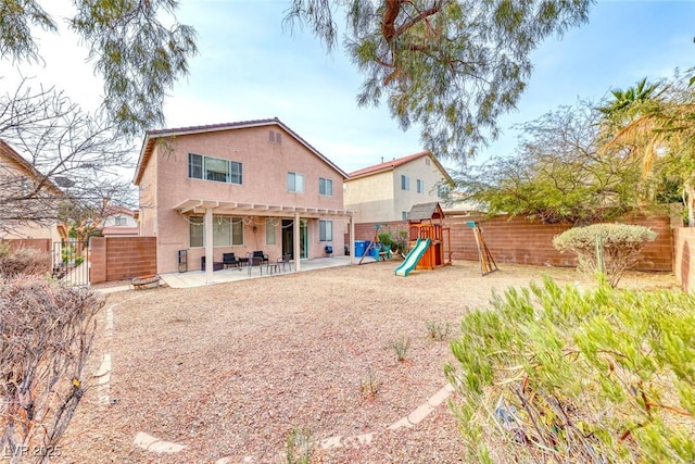 back of house featuring a patio, a fenced backyard, a playground, a pergola, and stucco siding