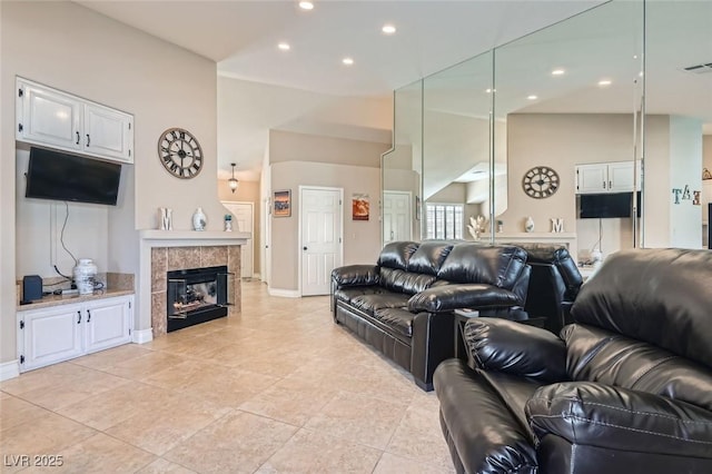 living area featuring light tile patterned floors, baseboards, a fireplace, high vaulted ceiling, and recessed lighting