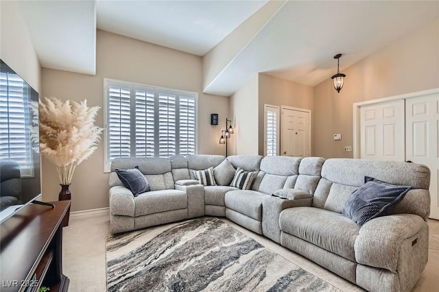 carpeted living area with baseboards and vaulted ceiling