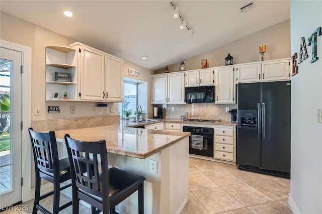 kitchen with visible vents, lofted ceiling, a peninsula, black appliances, and open shelves