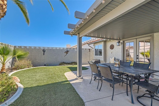 view of patio featuring outdoor dining space, french doors, and a fenced backyard