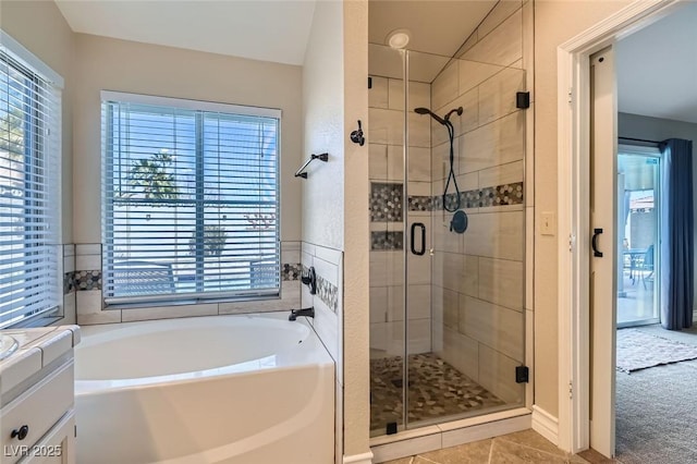 full bath featuring a stall shower, a garden tub, and tile patterned floors