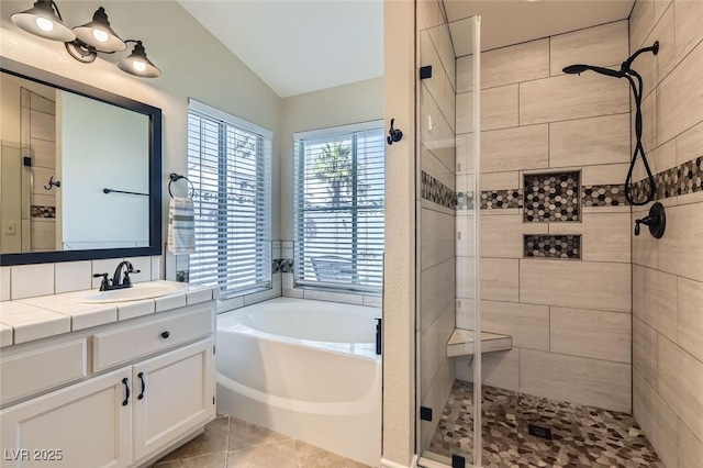 bathroom featuring a stall shower, tile patterned floors, a garden tub, vaulted ceiling, and vanity