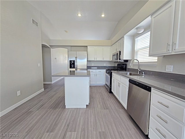 kitchen featuring visible vents, appliances with stainless steel finishes, white cabinetry, a sink, and baseboards