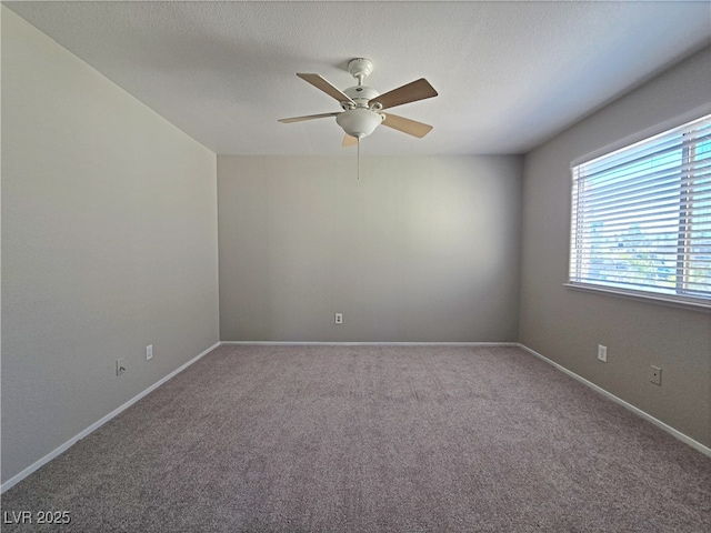 carpeted spare room featuring ceiling fan, a textured ceiling, and baseboards