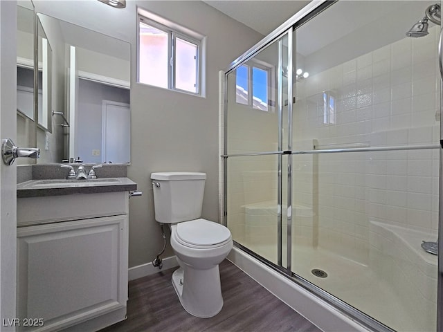 bathroom featuring a stall shower, vanity, toilet, and wood finished floors