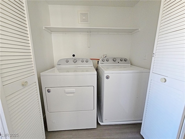 laundry room with laundry area, independent washer and dryer, and wood finished floors