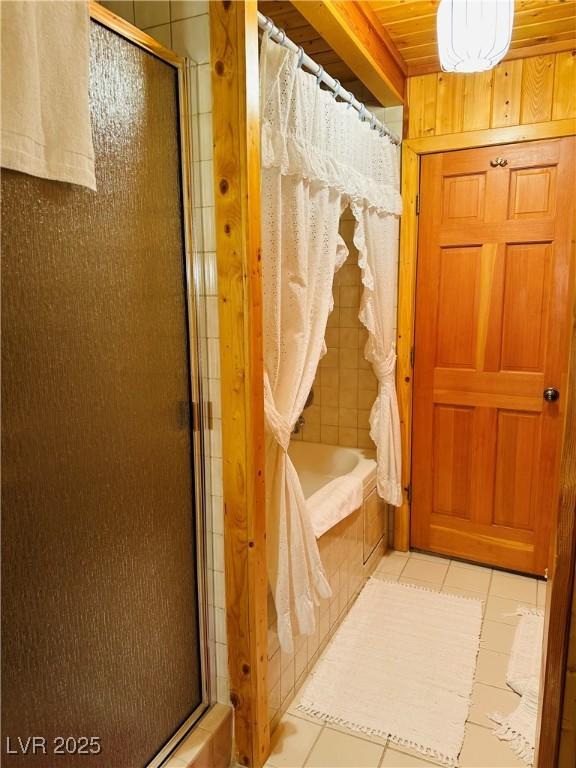 full bath featuring a tub, tile patterned flooring, and tiled shower