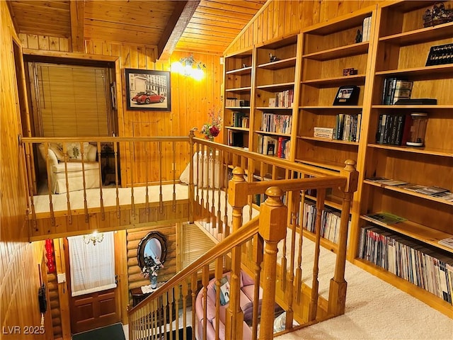 interior space with lofted ceiling with beams, carpet floors, wood walls, and wood ceiling