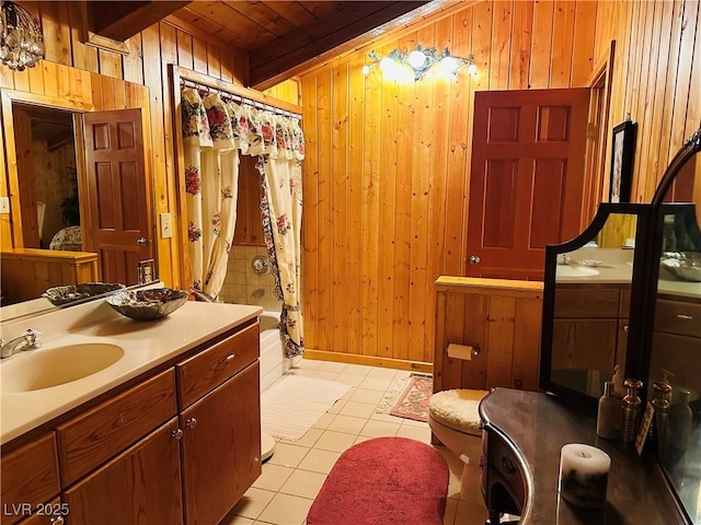 bathroom with beam ceiling, shower / tub combo, wood walls, vanity, and tile patterned flooring