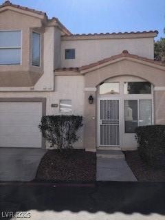 view of front of house featuring an attached garage, concrete driveway, and stucco siding