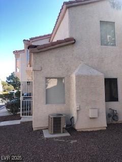 back of house featuring central air condition unit and stucco siding