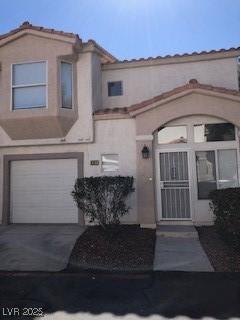 view of front of home featuring concrete driveway, an attached garage, and stucco siding