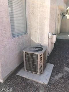 exterior details with cooling unit and stucco siding