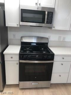 kitchen with light wood finished floors, light countertops, and appliances with stainless steel finishes