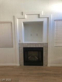 interior details with a fireplace, baseboards, and wood finished floors