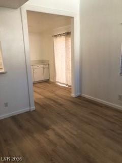 unfurnished room with baseboards and wood finished floors