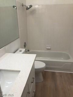 bathroom with shower / bath combination, vanity, toilet, and wood finished floors