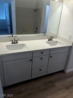 bathroom with double vanity, wood finished floors, a sink, and bathing tub / shower combination