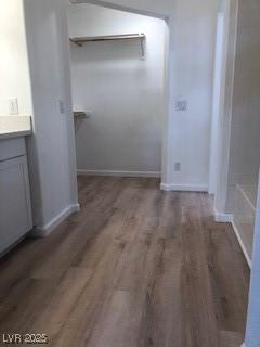 corridor with wood finished floors and baseboards