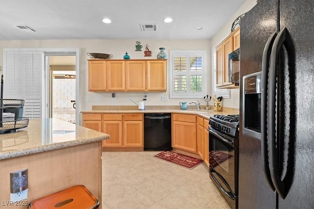 kitchen with a sink, black appliances, light brown cabinets, and recessed lighting