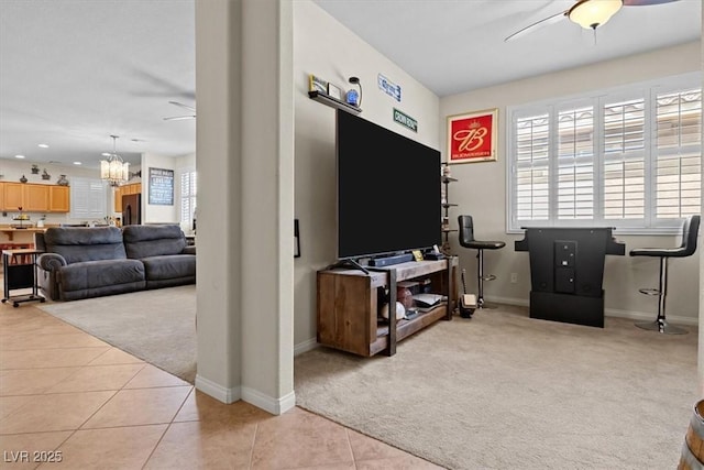 living room with light carpet, light tile patterned floors, baseboards, ceiling fan with notable chandelier, and recessed lighting