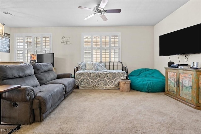 carpeted living room featuring ceiling fan and visible vents