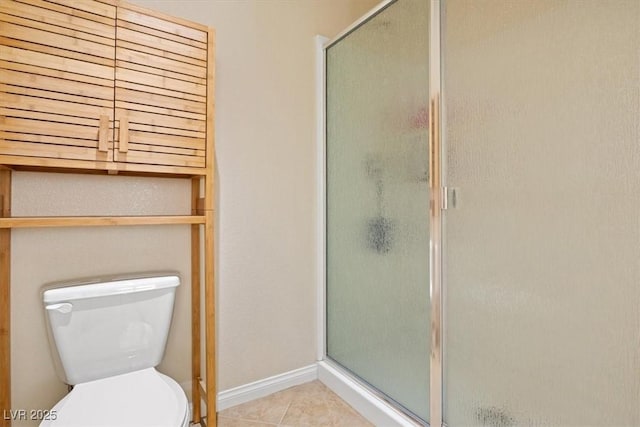 bathroom featuring baseboards, a shower stall, toilet, and tile patterned floors