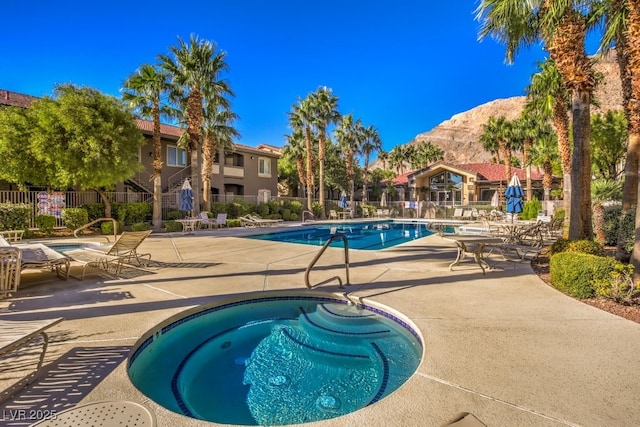 community pool featuring a patio area, fence, and a mountain view