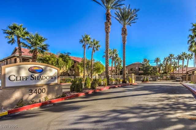 view of road featuring a residential view, a gate, a gated entry, and curbs