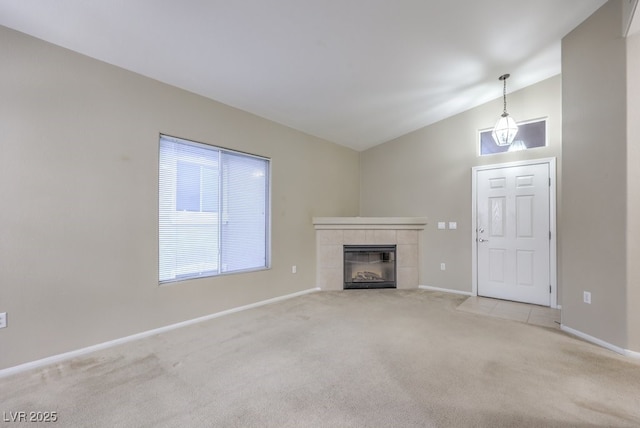 unfurnished living room with light carpet, a fireplace, baseboards, and lofted ceiling