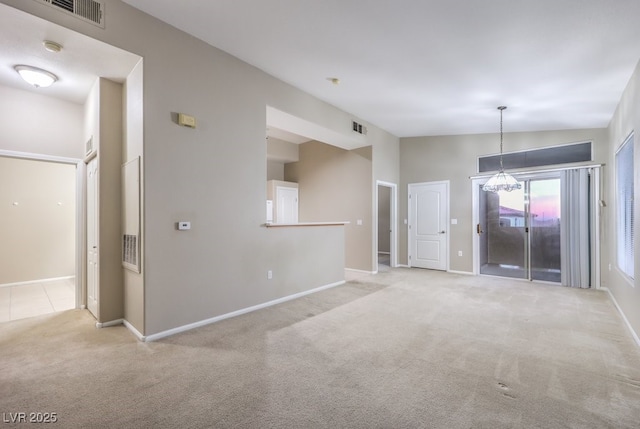 unfurnished room featuring vaulted ceiling, carpet flooring, visible vents, and baseboards