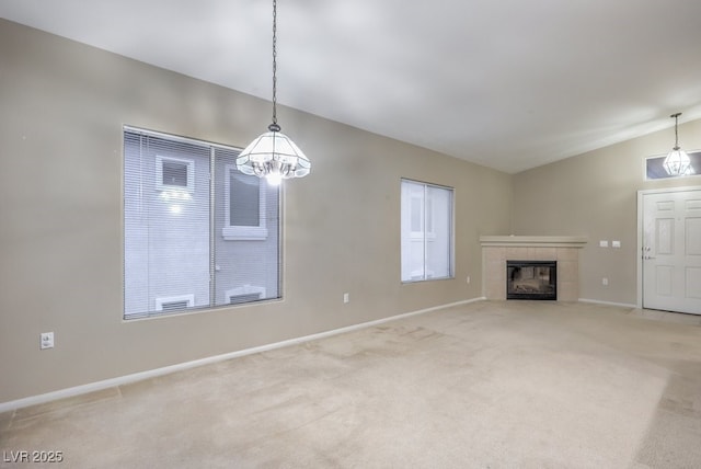 unfurnished living room featuring baseboards, light colored carpet, vaulted ceiling, and a tiled fireplace