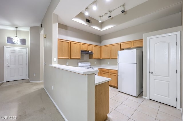 kitchen featuring visible vents, stove, freestanding refrigerator, light countertops, and under cabinet range hood