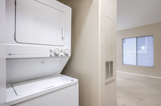 laundry area with a textured wall, stacked washer and dryer, laundry area, visible vents, and carpet