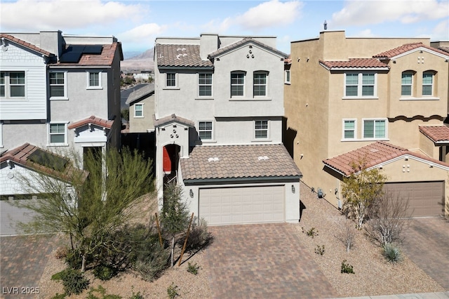 view of front of home with a garage, a tiled roof, decorative driveway, a residential view, and stucco siding