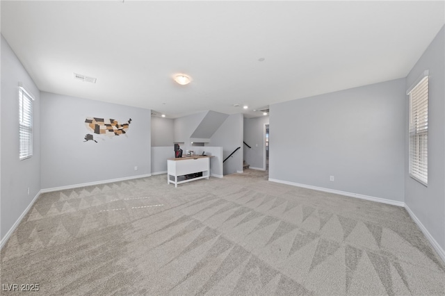 unfurnished living room featuring visible vents, baseboards, and carpet flooring