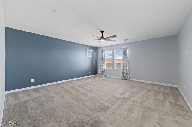 spare room with a ceiling fan, carpet, visible vents, and baseboards