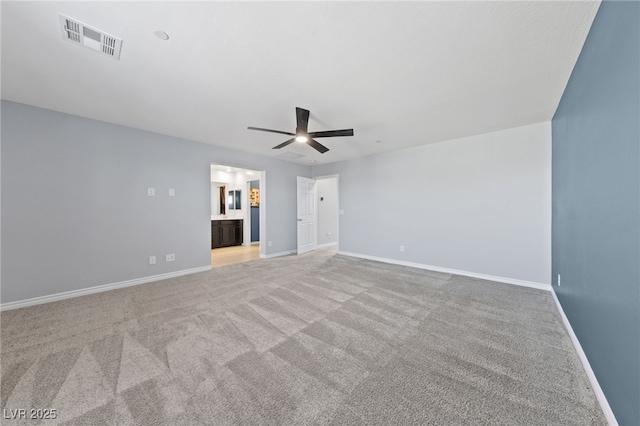 unfurnished bedroom with carpet floors, baseboards, visible vents, and ensuite bathroom